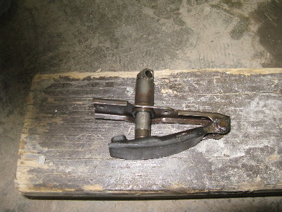 My primary chain tensioner.  From a 1983 CB1100, which had a big laminated chain as a primary drive that was tensioned by this thing.  It has a small hole at the bottom of the piston that pushes out on the tensioner.  The piston was fed with engine oil pressure to keep the chain tight, and to oil it, I suppose through the little hole.  I'm going to plug the oil hole, and then tap a grease fitting to the end of the "cylinder" which will stick out of the top of my primary case, and I can tension my primary chain (a double #40) with grease.