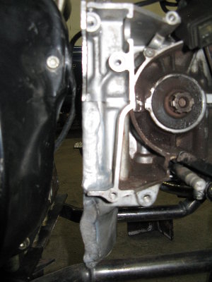 The side of the transmission.  1/8" aluminum welded to the bottom case.  Holes drilled and tapped to the top case which, in conjunction with lots of RTV should keep oil from spewing out..  I also welded a small block of aluminum with a tapped hole to the top of the tranmission into which I put a dipstick that I built to check my transmission oil.  I'm trying to think of these things as I go, because once this thing is on the road I'm not going to want to keep taking it apart.